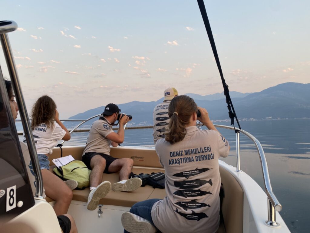 wild life conservation tours: an image of young people on a boat observing with binoculars